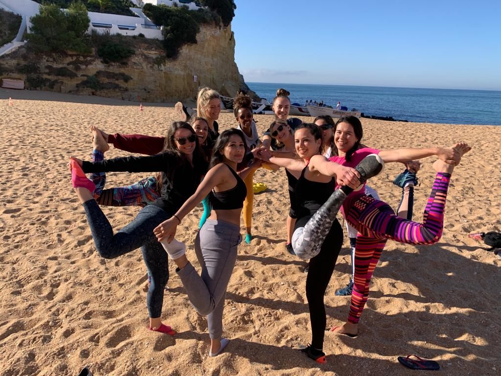 Women of a retreat group practising together on the beach in Portugal